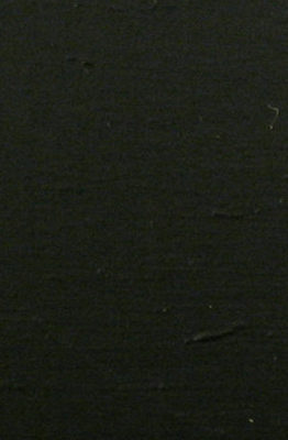 Black paper with ripples on top of flat surface.