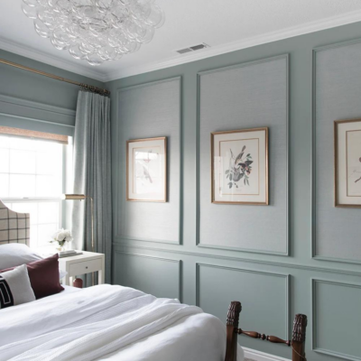 Bedroom with blue wainscoting walls and three large photos