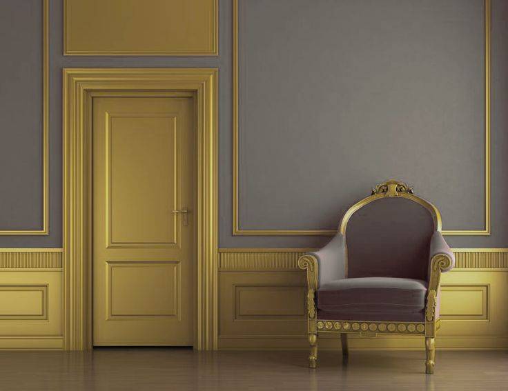 Wainscotting in room with gold door, gold wainscotting trim and gray walls. Gray and gold accent chair.