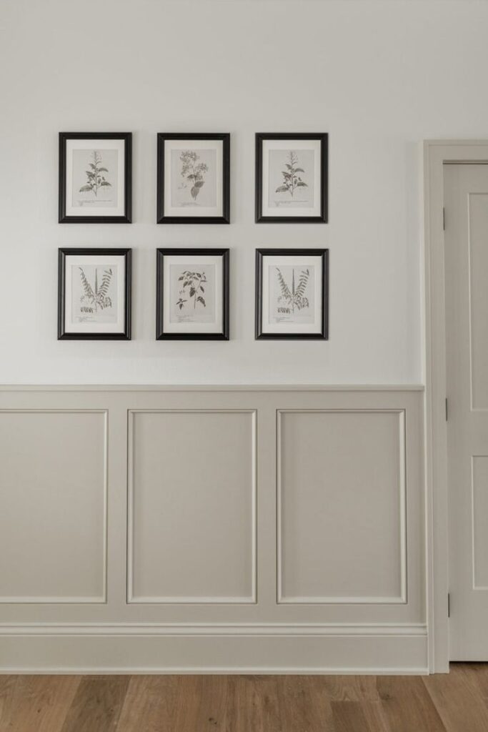 Taupe wainscoting on entryway wall with six pictures above.