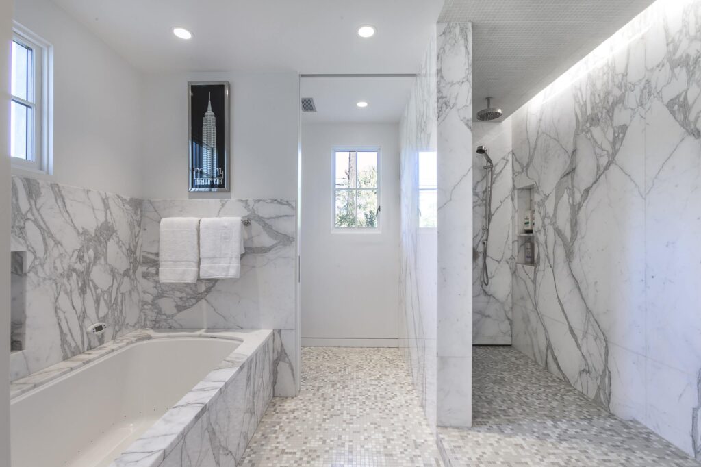 Bathroom with gray and white marble wainscoting around tub and in shower