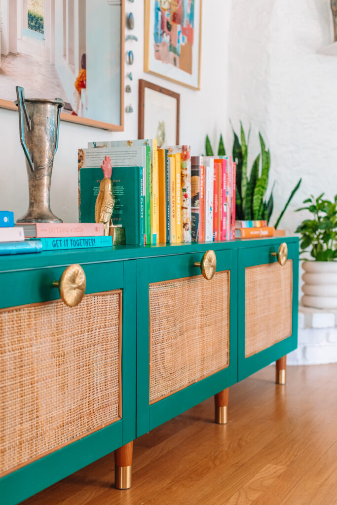 Rattan Ikea Besta with turquoise trim and gold knobs.