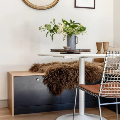 Black and wooden Ikea BESTIA bench behind white table.