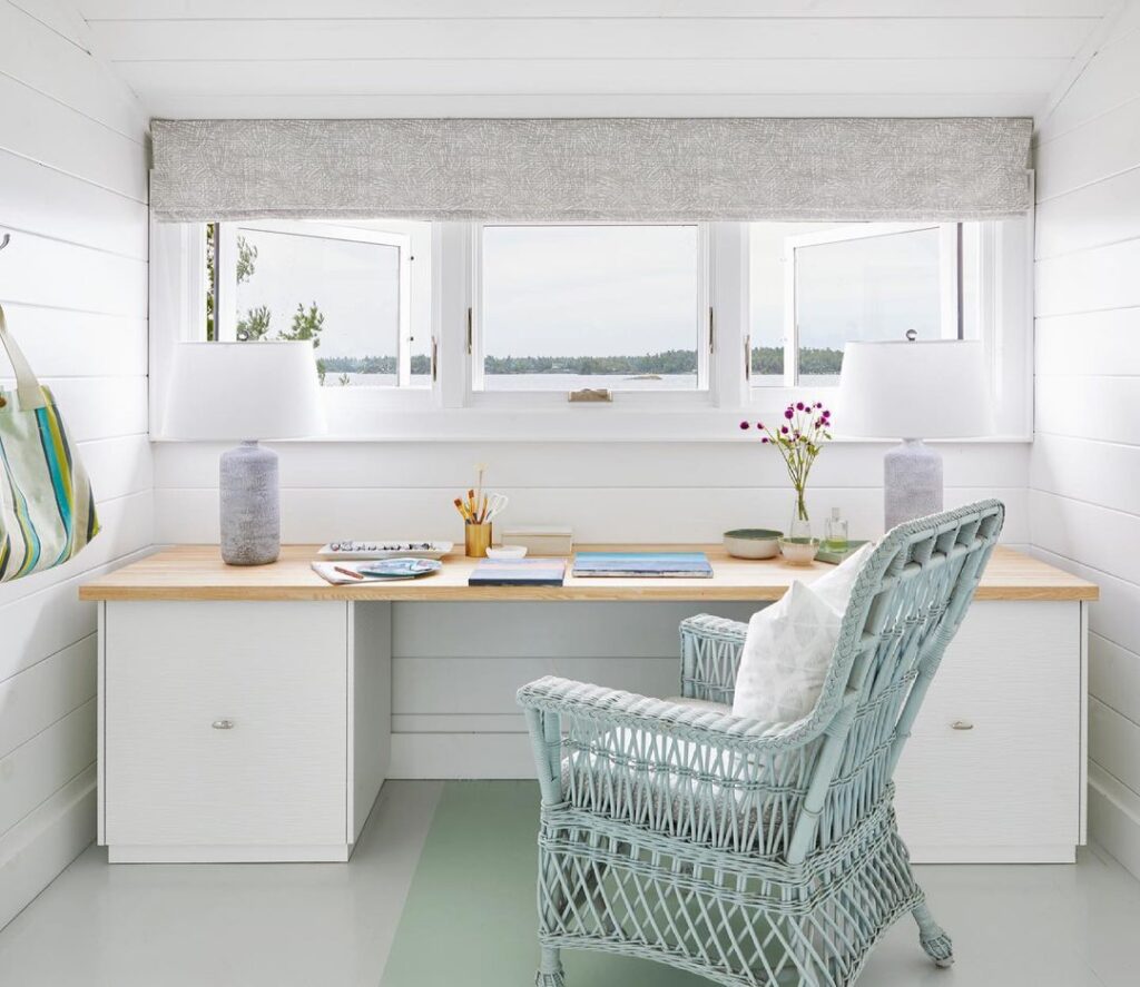 White Ikea BESTA used as an office desk with wood countertop in front of large window 