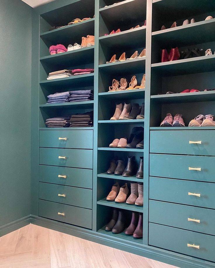 Turquoise blue IKEA shelf open shelf with shoes and sweaters inside.