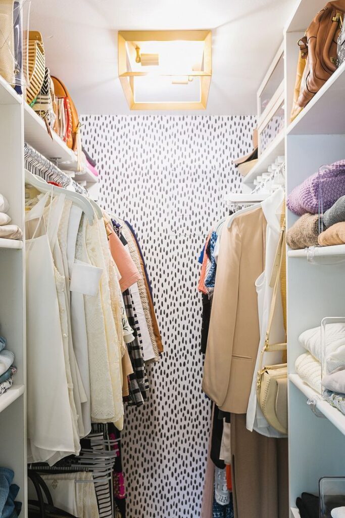 Walk-in closet with speckled white and black wallpaper 