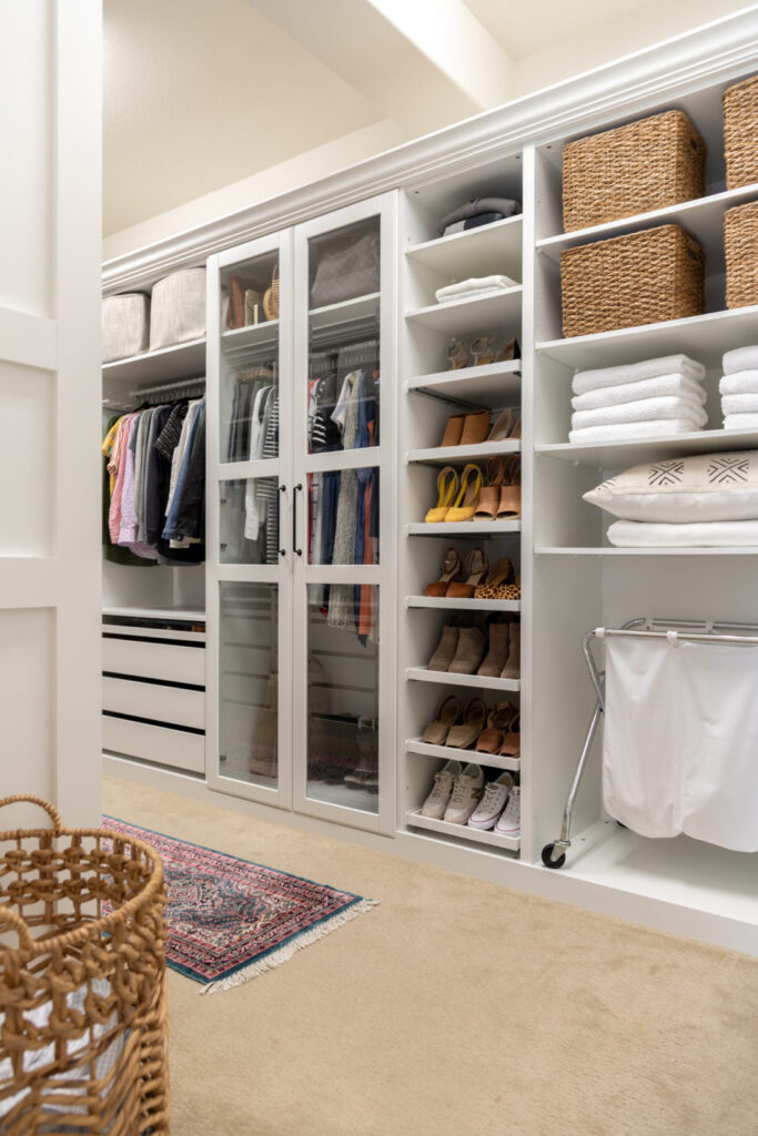 White IKEA closet unit withe shoes and white laundry basket inside.