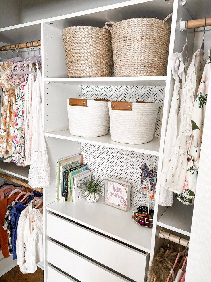 IKEA white kids closet with baskets on two shelves and drawers