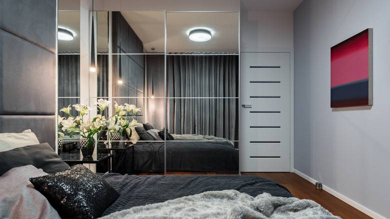 IKEA wardrobe with mirrored doors in bedroom with grey walls and large bed