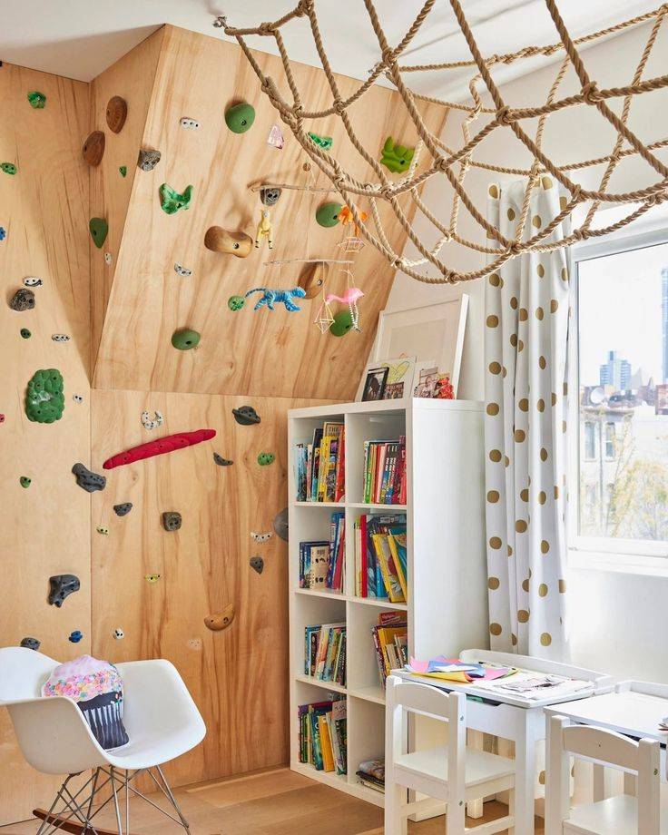 Climbing wall in kids bedroom with multi-colored rocks 