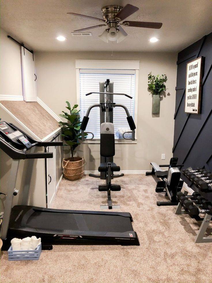 Small carpeted room with treadmill , bikes and weights