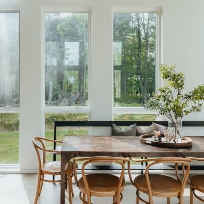 a dining room table with chairs and a vase of flowers